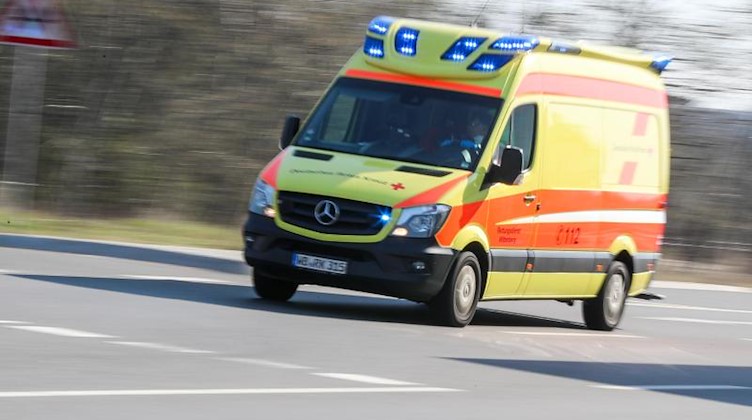 Ein Krankenwagen verlässt mit Blaulicht einen Ort. Foto: Jan Woitas/dpa-Zentralbild/dpa/Symbol