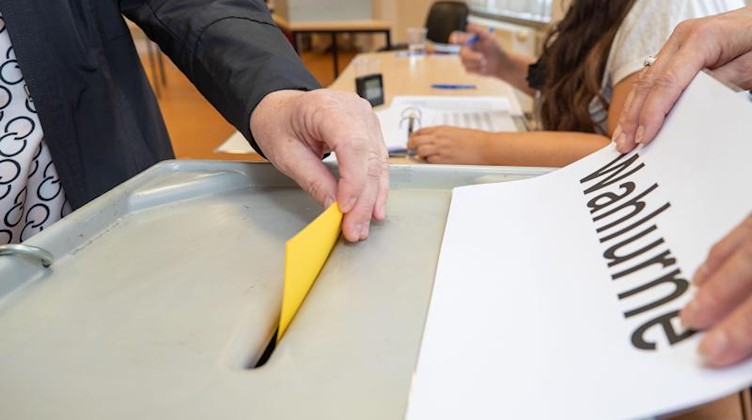 Eine Frau steckt ihren Stimmzettel in einem Wahllokal in eine Wahlurne. Foto: Daniel Schäfer/dpa-Zentralbild/dpa