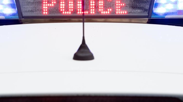"Police" steht auf dem Display eines Polizeiwagens mit angeschaltetem Blaulicht. Foto: Friso Gentsch/dpa/Archivbild