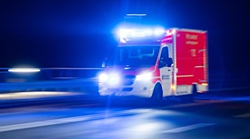 Ein Rettungswagen der Feuerwehr fährt mit Blaulicht durch eine Straße. Foto: Marcel Kusch/dpa/Symbolbild