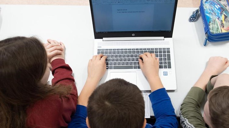 Schüler einer 3. Klasse sitzen vor einem Laptop. Foto: Sebastian Kahnert/dpa-Zentralbild/dpa/Symbolbild