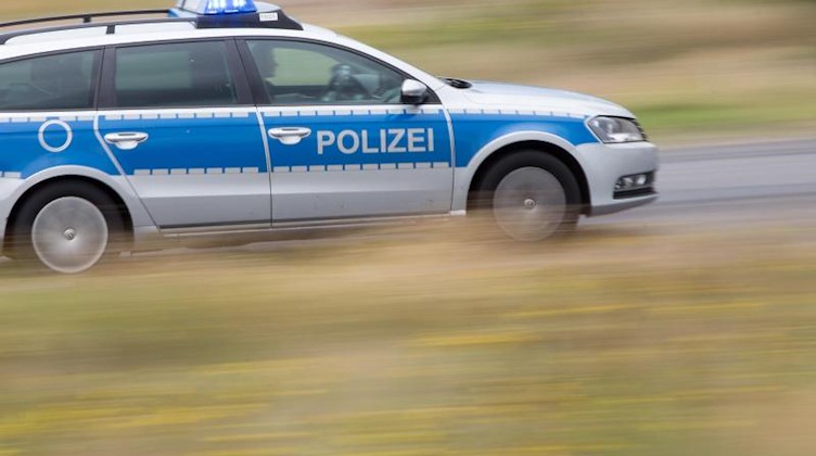 Ein Polizeifahrzeug fährt mit Blaulicht auf der Landstraße. Foto: Friso Gentsch/dpa/Symbolbild