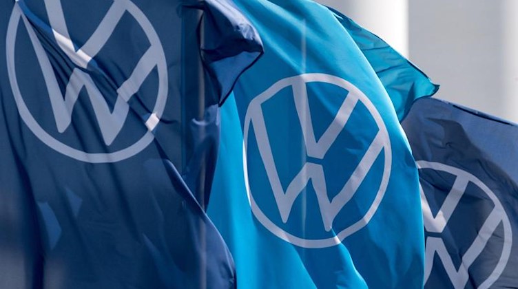 Fahnen mit dem VW-Logo wehen im Fahrzeugwerk von Volkswagen. Foto: Hendrik Schmidt/dpa-Zentralbild/dpa