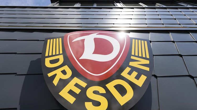 Ein Logo der SG Dynamo Dresden ist am Trainingszentrum an der Fassade angebracht. Foto: Robert Michael/dpa-Zentralbild/dpa/Archiv