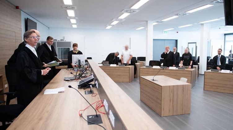 Hans Schlüter-Staats (l), Vorsitzender Richter am Oberlandesgericht, steht zu Prozessbeginn im Verhandlungssaal des Oberlandesgerichts (OLG) vor den Angeklagten. Foto: Sebastian Kahnert/dpa-Zentralbild/dpa/Aktuell