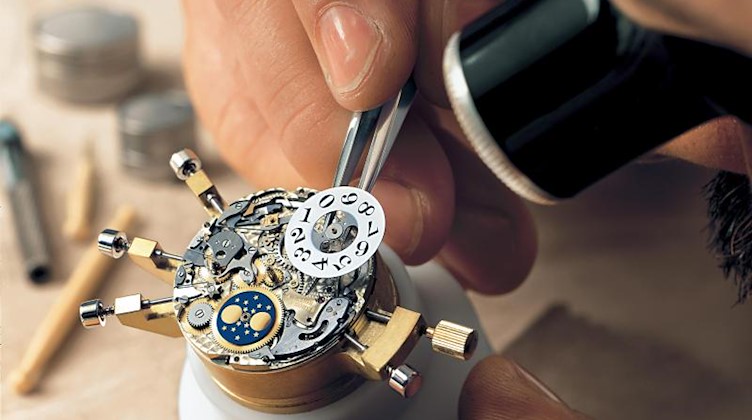 Ein Mitarbeiter des Luxus-Uhrenmachers A. Lange und Söhne montiert das Großdatum. Foto: A. Lange und Söhne/A._Lange_und_Söhne/dpa/Archivbild