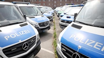 Polizeimannschaftswagen parken auf dem Gelände eines Polizeipräsidiums. Foto: Roland Weihrauch/dpa/Symbol