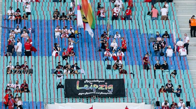 Fans sitzen mit Abstand im Stadion. Foto: Jan Woitas/dpa-Zentralbild/dpa