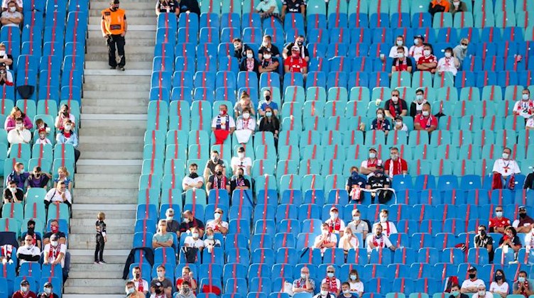 Fans sitzen mit Abstand im Stadion. Foto: Jan Woitas/dpa-Zentralbild/dpa