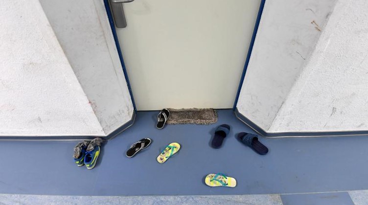 Schuhe liegen vor dem Zimmer einer Erstaufnahmeeinrichtung für Flüchtlinge. Foto: Ralf Hirschberger/dpa-Zentralbild/dpa/Archivbild