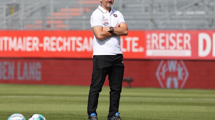 Aue-Trainer Dirk Schuster steht vor Spielbeginn auf dem Platz. Foto: Daniel Karmann/dpa/Archivbild