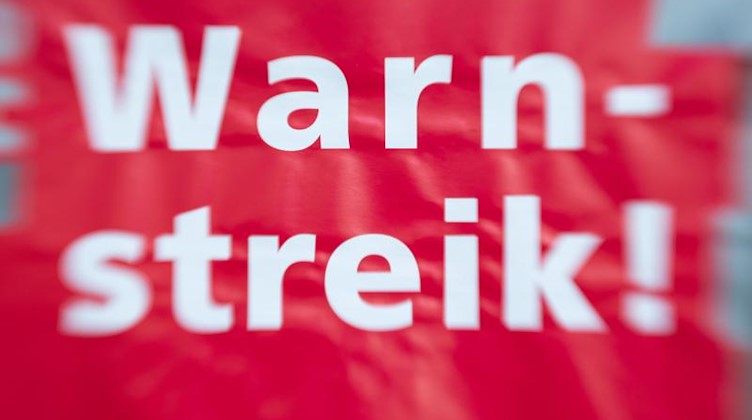 «Warnstreik!» steht auf einem Schild bei einem Warnstreik. Foto: Friso Gentsch/dpa/Symbolbild