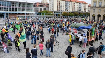 Teilnehmer einer Aktion der Klimabewegung Fridays For Future stehen auf dem Altmarkt. Foto: Sebastian Kahnert/dpa-Zentralbild/dpa