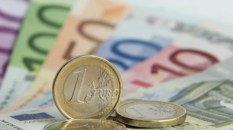 Euro-Münzen auf Euro-Banknoten. Foto: Daniel Reinhardt/dpa/Symbolbild