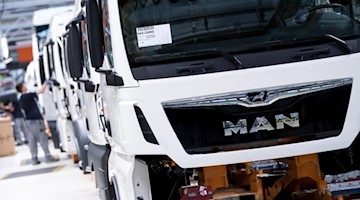 Mitarbeiter von MAN Truck & Bus arbeiten in einer Produktionsstraße. Foto: Sven Hoppe/dpa/Archivbild