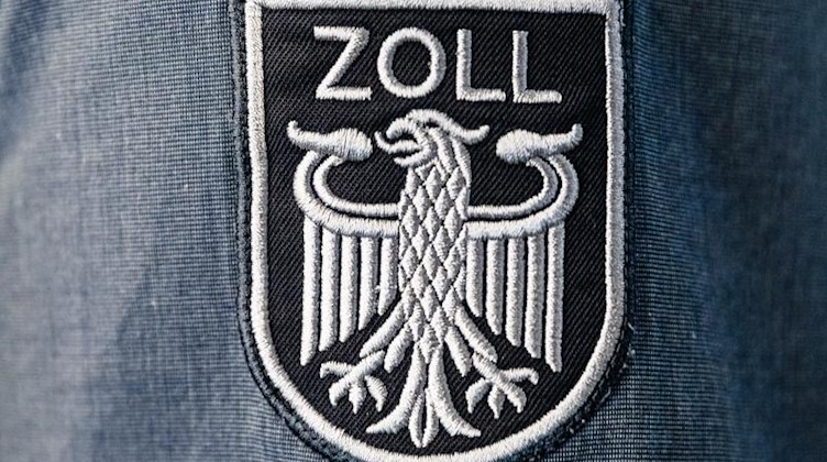 Das Wappen des Zolls ohne die Bundesfarben ist auf der Arbeitsuniform eines Beamten angebracht. Foto: Markus Scholz/dpa/Archiv