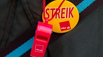 Trillerpfeife und Button mit der Aufschrift «Streik». Foto: Daniel Bockwoldt/dpa/Symbolbild