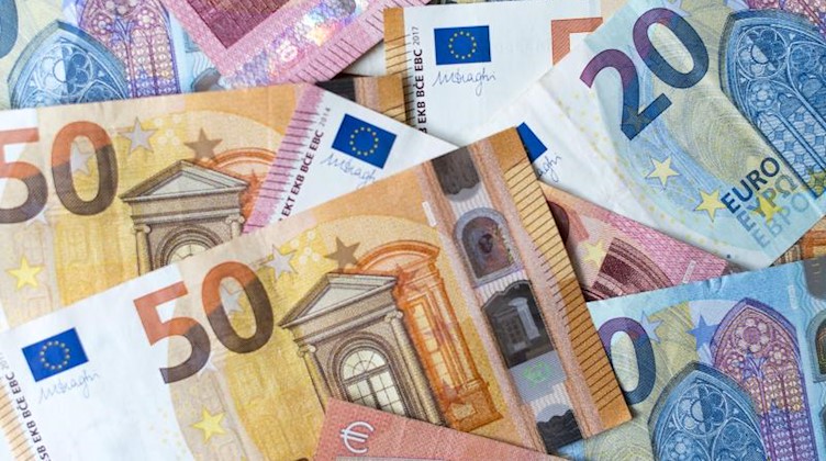 Zahlreiche Banknoten zu 10, 20 und 50 Euro liegen auf einem Tisch. Foto: Monika Skolimowska/dpa-Zentralbild/dpa/Illustration