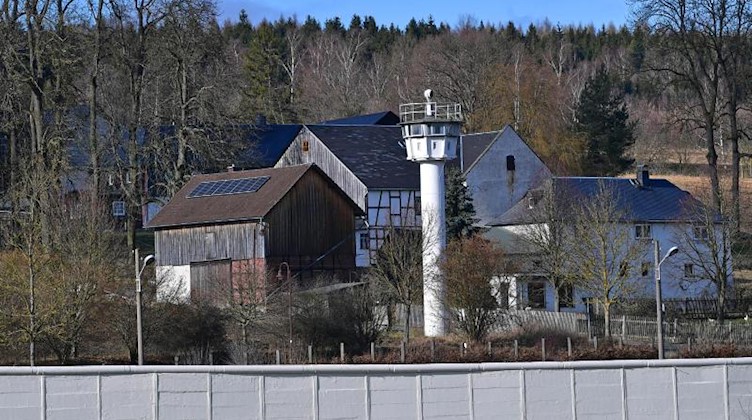 Die Mauer und ein Wachturm stehen mitten im Dorf Mödlareuth. Foto: Martin Schutt/dpa-Zentralbild/dpa/Archivbild