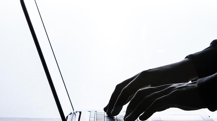 Ein Mann tippt auf der Tastatur eines Laptops. Foto: Silas Stein/dpa/Symbolbild