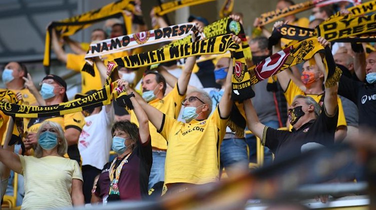 Dynamos Fans halten Schals hoch. Foto: Robert Michael/dpa-Zentralbild/dpa
