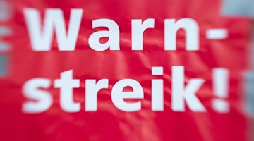 «Warnstreik!» steht auf einem Schild. Foto: Friso Gentsch/dpa/Symbolbild