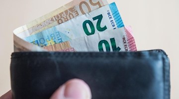 Geldscheine stecken in einem Geldbeutel. Foto: Lino Mirgeler/dpa/Symbolbild