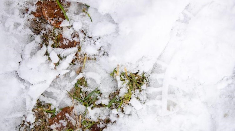 Fußspuren von Wanderschuhen im Schnee. Foto: Daniel Karmann/dpa/Symbolbild