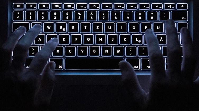 Ein Mann benutzt die beleuchtete Tastatur eines Notebooks. Foto: Silas Stein/dpa/Symbolbild