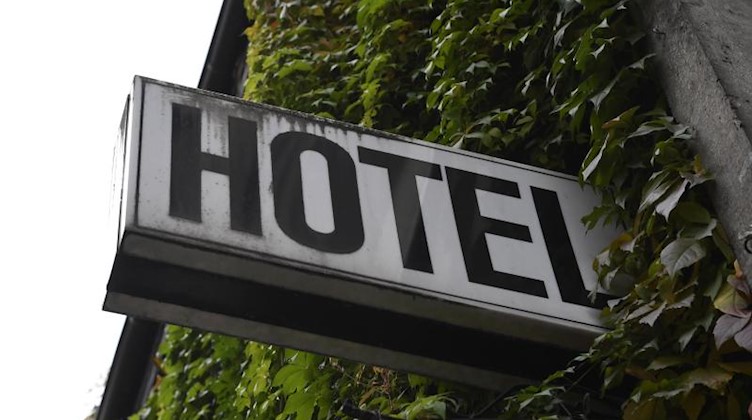 Ein «Hotel»-Schild ist an der Wand eines Gebäudes angebracht. Foto: Roberto Pfeil/dpa/Symbolbild