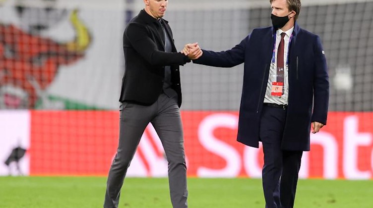 Julian Nagelsmann (l) und Markus Krösche geben sich nach dem Spiel die Hand. Foto: Jan Woitas/dpa-Zentralbild/dpa