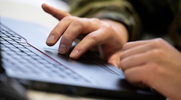 Ein Bundeswehrsoldat arbeitet an einem Laptop. Foto: Marijan Murat/dpa/Symbolbild