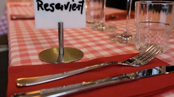 Ein Schild mit der Aufschrift «Reserviert» steht auf einem Tisch in einem Restaurant. Foto: Marcus Brandt/dpa/Archiv/Symbolbild