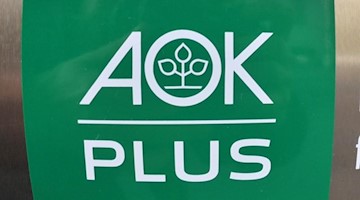 Blick auf das Logo der AOK Plus an einer Erfurter Filiale. Foto: Martin Schutt/dpa-Zentralbild/dpa/Archivbild