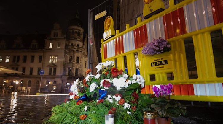 Blumen und Kerzen zum Gedenken an die Opfer der Messerattacke unweit des Residenzschlosses. Foto: Sebastian Kahnert/dpa-Zentralbild/dpa