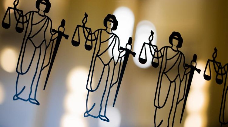 Die Justitia ist an einer Türscheibe angebracht. Foto: Rolf Vennenbernd/dpa/Symbol