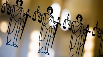 Die Justitia ist an einer Türscheibe angebracht. Foto: Rolf Vennenbernd/dpa/Symbol