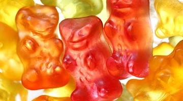 Gummibärchen von Haribo liegen auf einem Tisch. Foto: Martin Gerten/dpa/Illustration