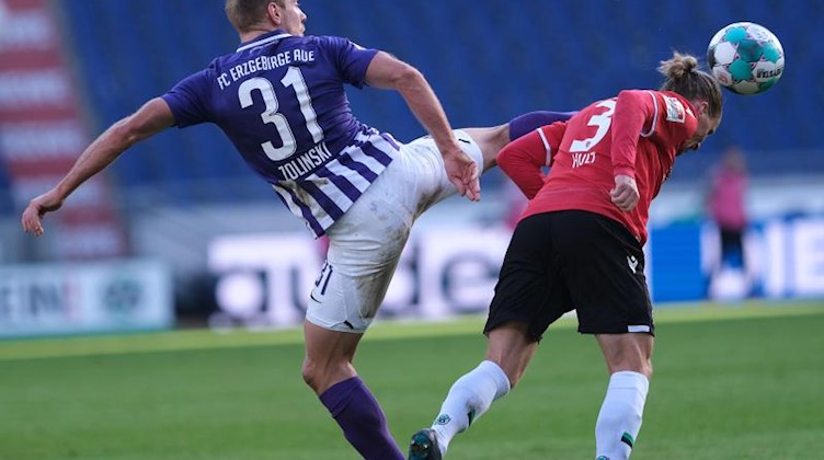 Aues Ben Zolinski (l) und Hannovers Niklas Hult kämpfen um den Ball. Foto: Peter Steffen/dpa