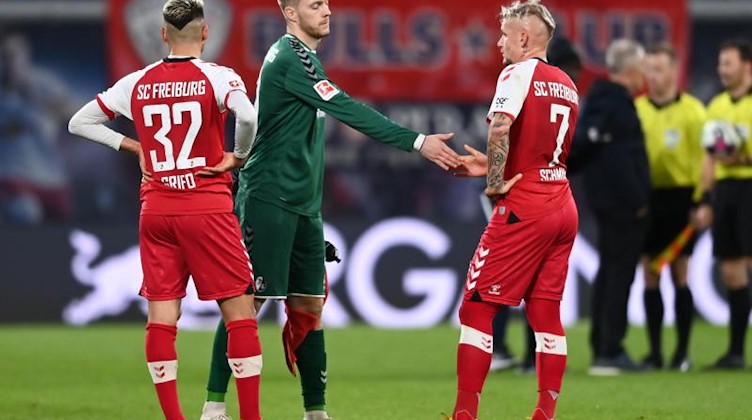 Freiburgs Vincenzo Grifo (v.l.), Florian Müller und Jonathan Schmid reagieren nach dem Spiel. Foto: Hendrik Schmidt/dpa-Zentralbild/dpa