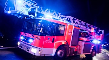 Ein Drehleiterwagen der Feuerwehr mit Blaulicht. Foto: Marcel Kusch/dpa/Symbolbild