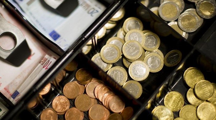 Euromünzen- und Scheine liegen in einer Kasse. Foto: picture alliance/dpa/Symbolbild