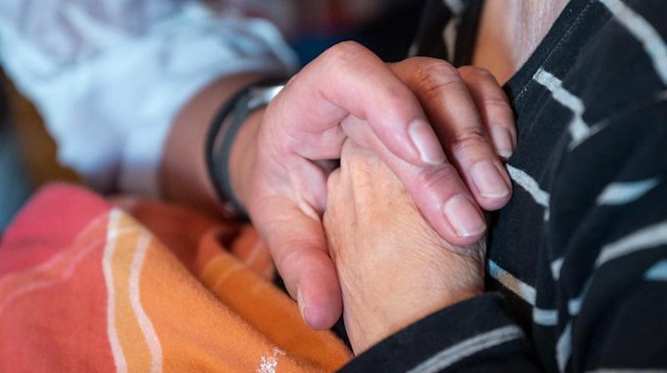 Eine Pflegekraft kümmert sich um eine Patientin. Foto: Bernd Thissen/dpa/Archivbild