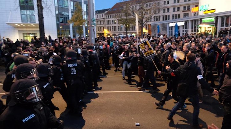 Teilnehmer der «Querdenken»-Demo in Leipzig stehen Polizisten gegenüber. Foto: Sebastian Willnow/dpa-Zentralbild/dpa/Archivbild