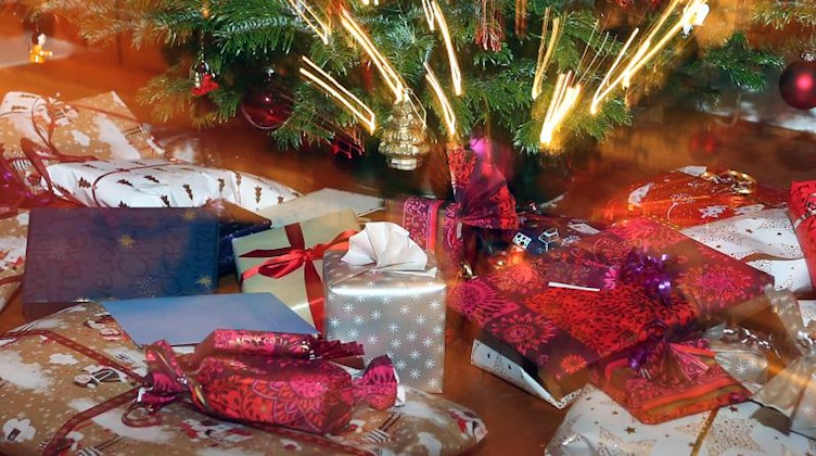 Verpackte Weihnachtsgeschenke liegen unter einem Christbaum. Foto: Karl-Josef Hildenbrand/dpa/Symbolbild