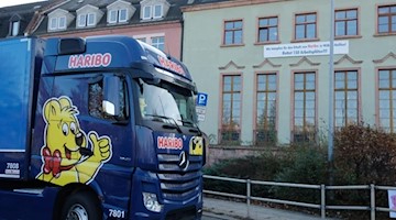 Ein LKW mit Haribo-Beschriftung fährt am Rathaus vorbei. Foto: Sebastian Willnow/dpa-Zentralbild/dpa