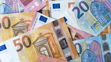 Zahlreiche Banknoten zu 10, 20 und 50 Euro liegen auf einem Tisch. Foto: Monika Skolimowska/zb/dpa/Symbolbild