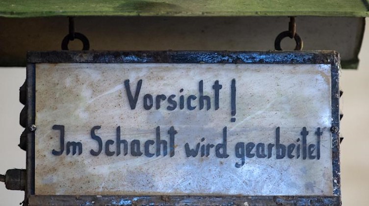 "Vorsicht! Im Schacht wird gearbeitet" steht auf einem Schild. Foto: Hendrik Schmidt/dpa-Zentralbild/ZB/Sybolbild