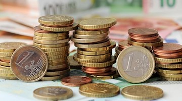 Euro-Münzen auf Euro-Banknoten. Foto: Tobias Hase/dpa/Symbolbild