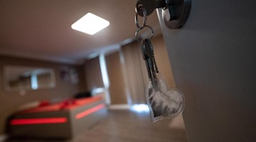 Ein Schlüssel steckt im Türschloss zu einem Zimmer in einem Laufhaus. Foto: Sebastian Gollnow/dpa/Symbolbild